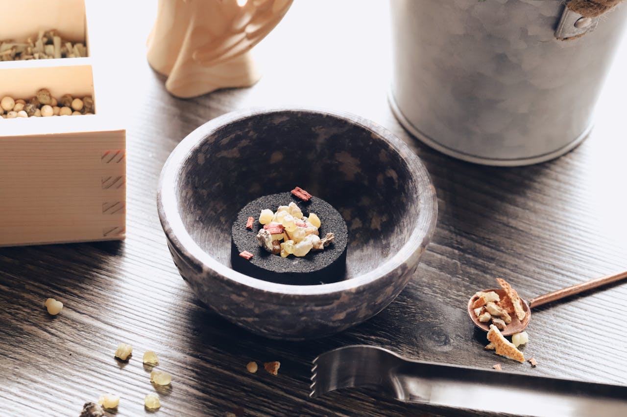 A beautifully arranged mix of incense ingredients in a rustic bowl, captured on a wooden table with natural light.
